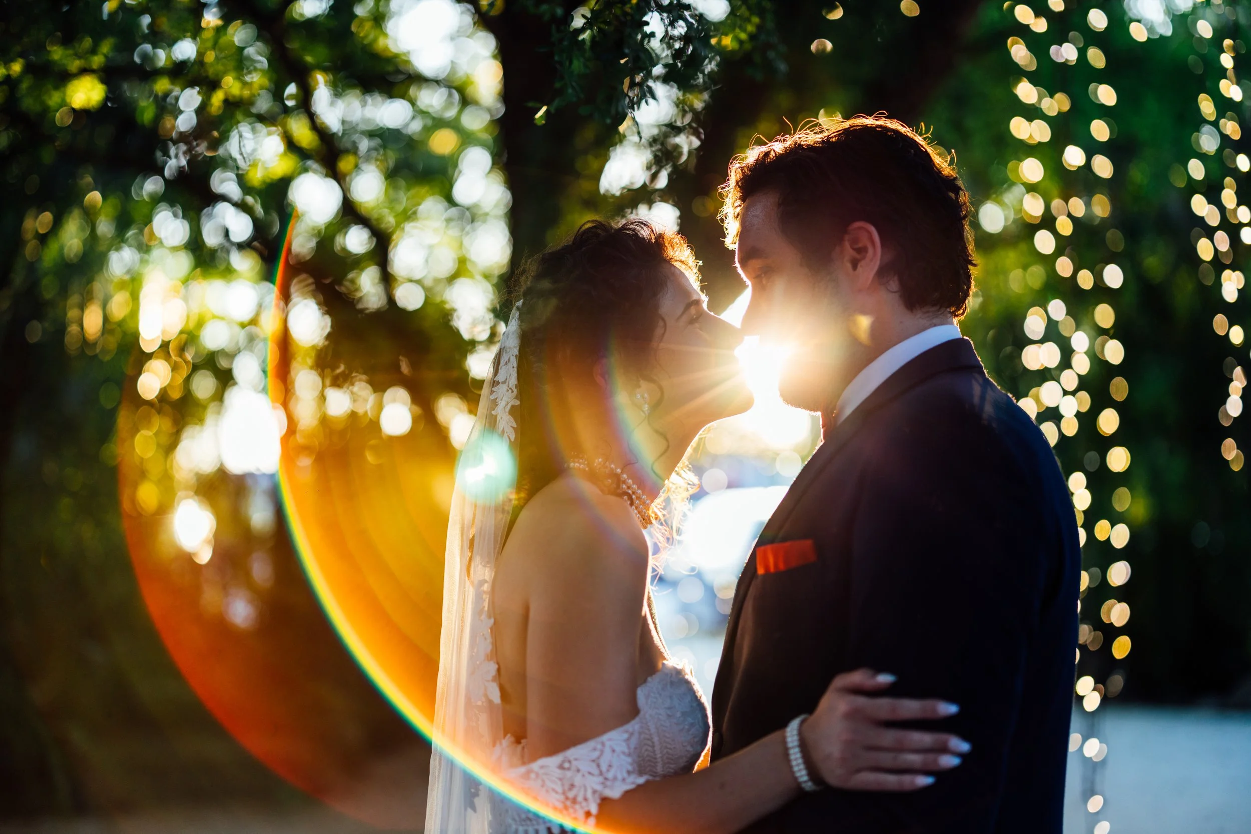 Newlyweds sharing a sunlit kiss