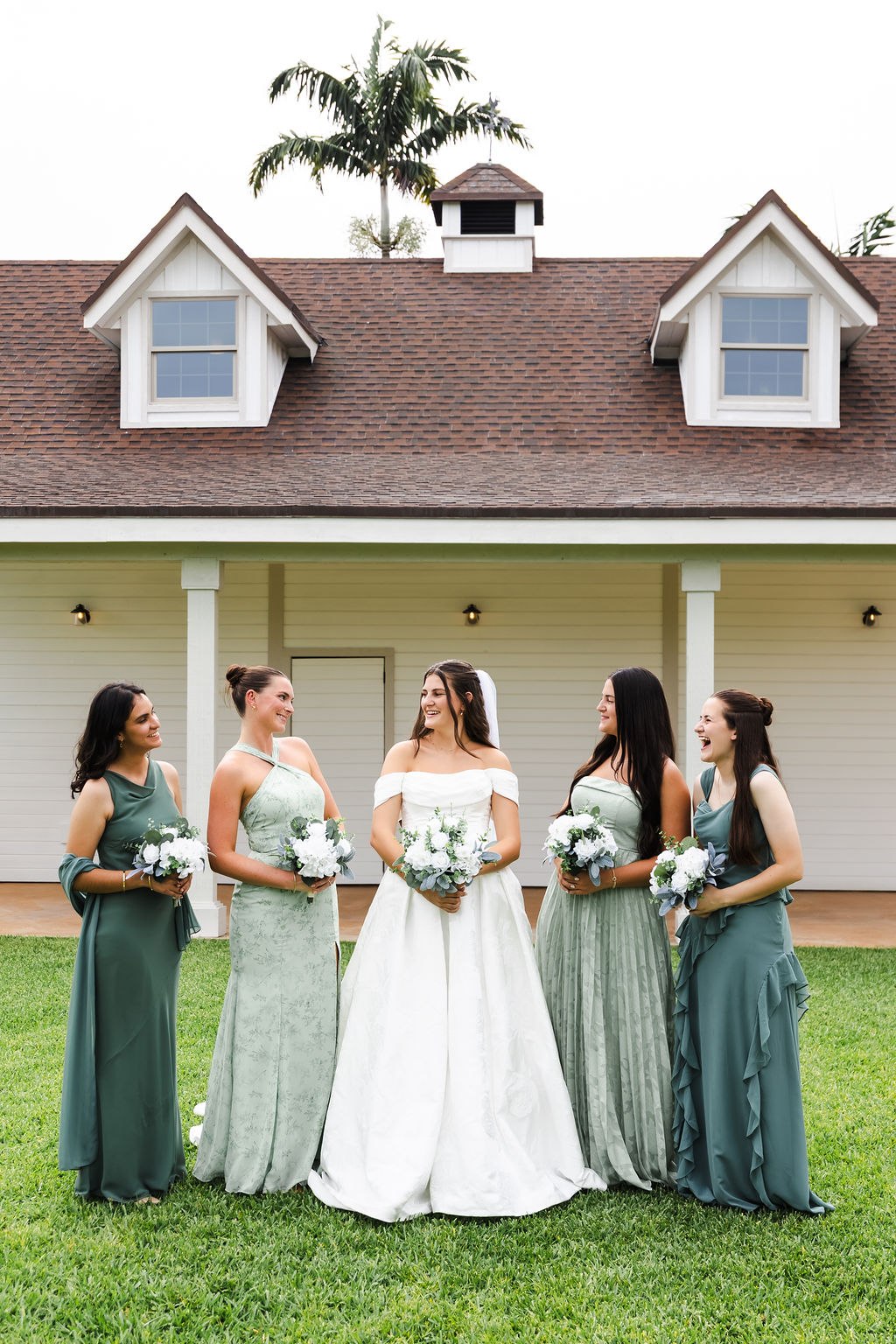 Leah with her bridesmaids in green dresses on the estate lawn