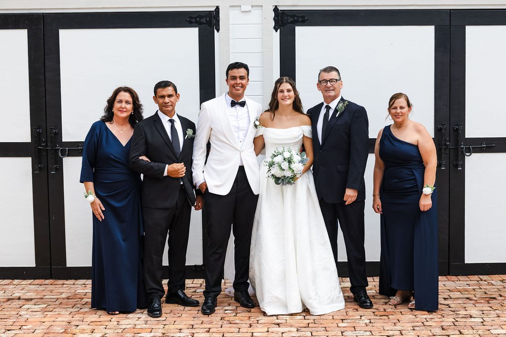 Leah and Jose with family in front of the barn doors