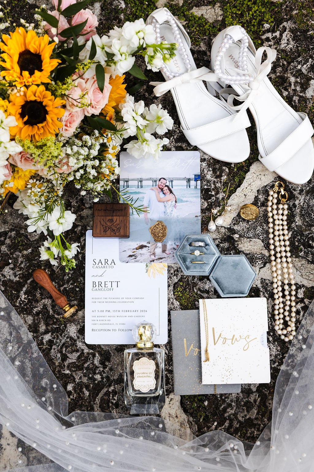 Sara and Brett’s wedding details arranged with sunflowers and bridal shoes