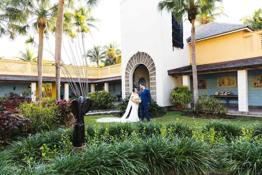 Sara and Brett framed by the courtyard gardens and arched tower