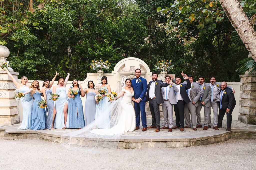 Sara and Brett celebrating with their wedding party at the fountain