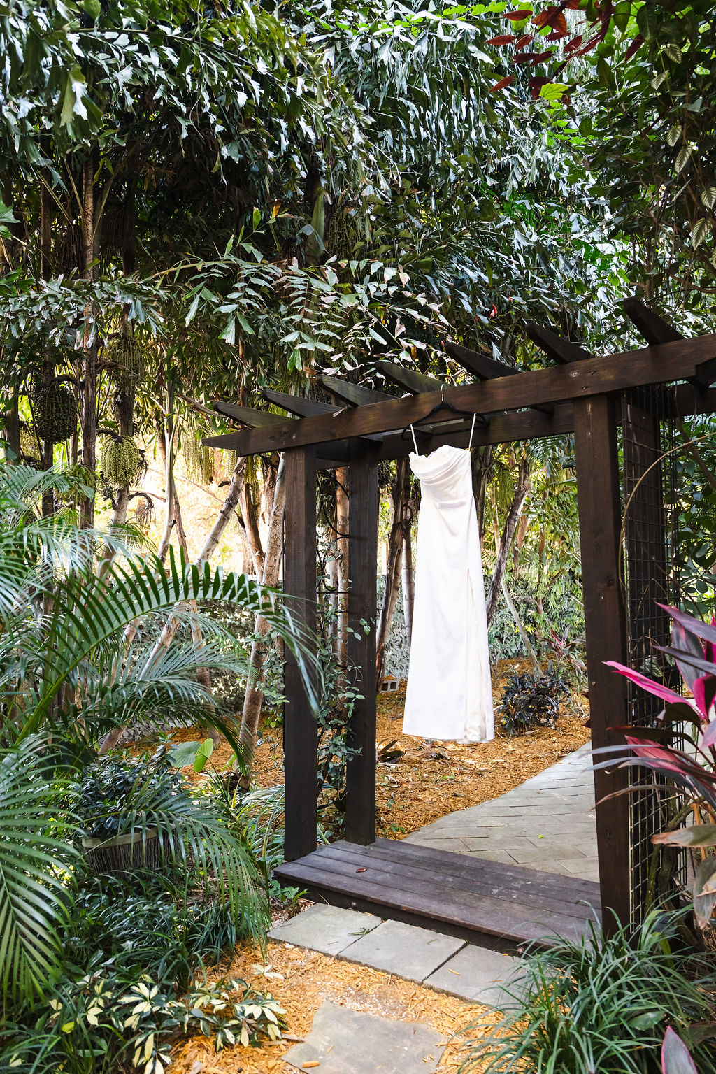 Bryn's wedding dress hanging in the tropical garden