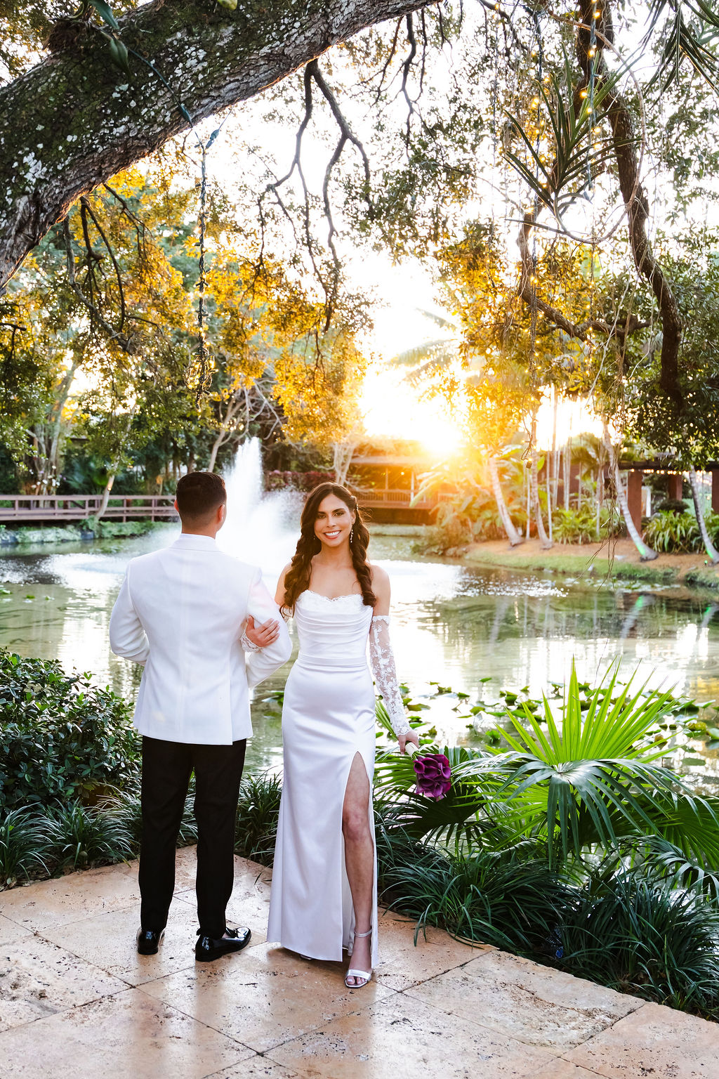 Golden-hour wedding portrait beside the pond and waterfall