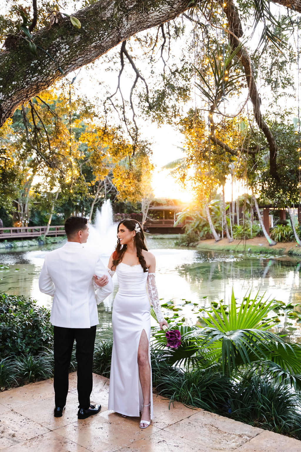 Bryn and Edward looking at one another beside the koi pond at sunset
