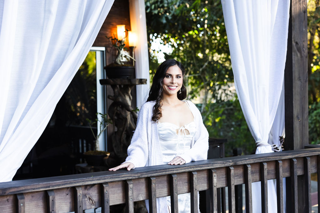 Bryn smiling from a wood balcony before the ceremony