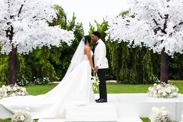 Chrispin and Netania holding hands at their White Orchid ceremony