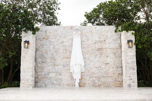 Netania's wedding dress displayed against a stone wall