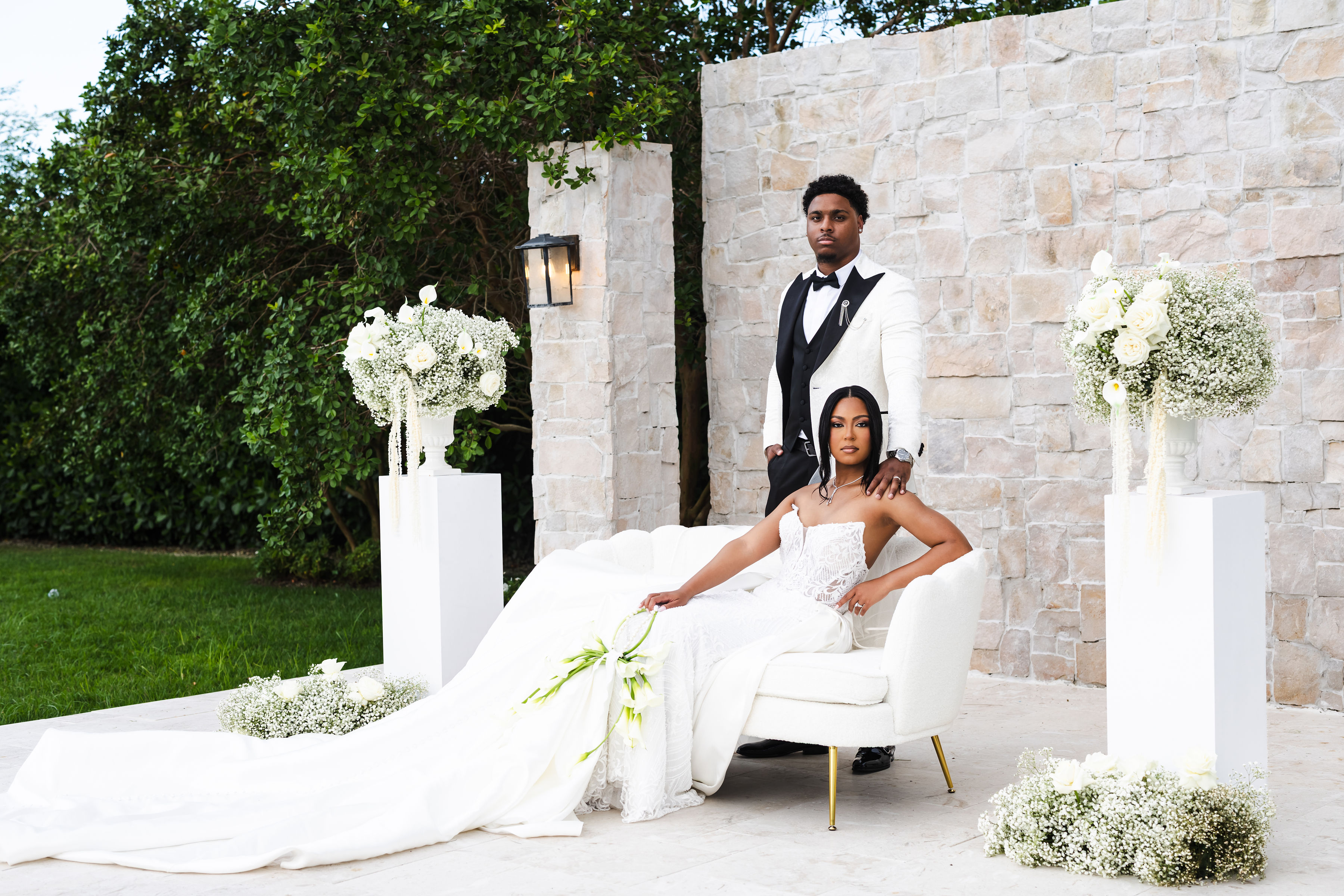 Netania seated among white floral ceremony décor