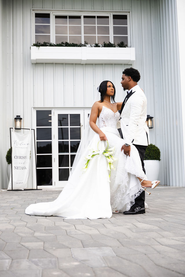 Chrispin and Netania embracing outside the all-white venue