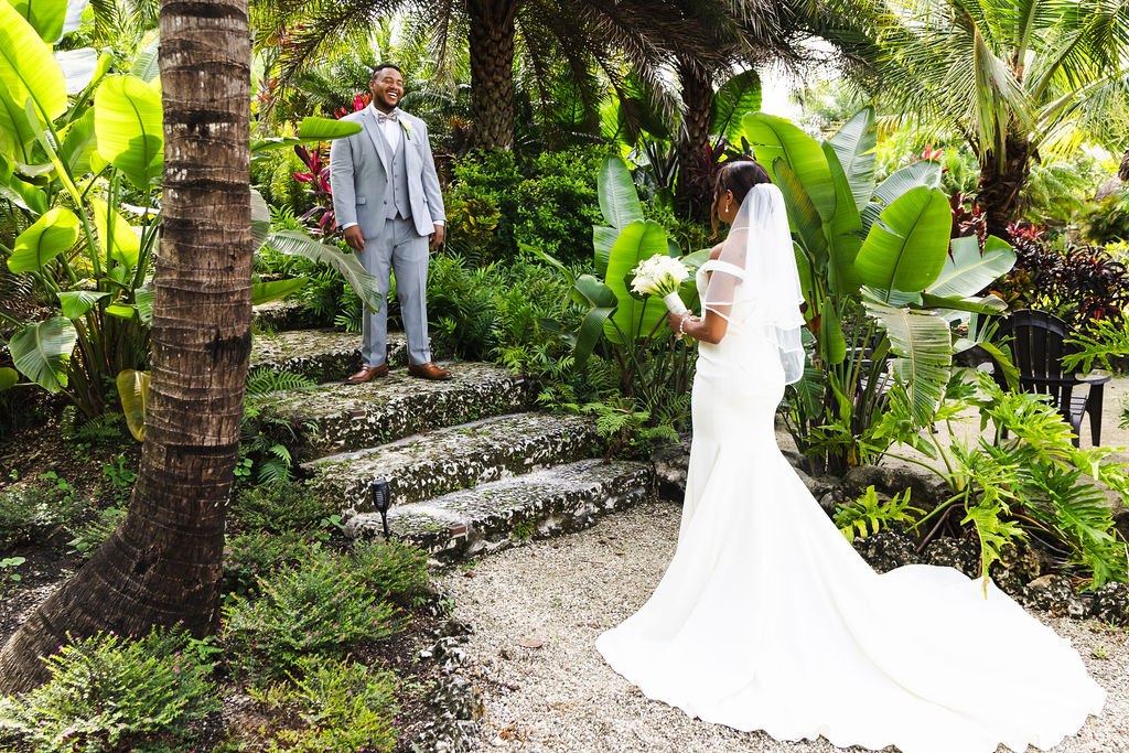 Sharlena approaching Adrian on the stone steps in the tropical garden