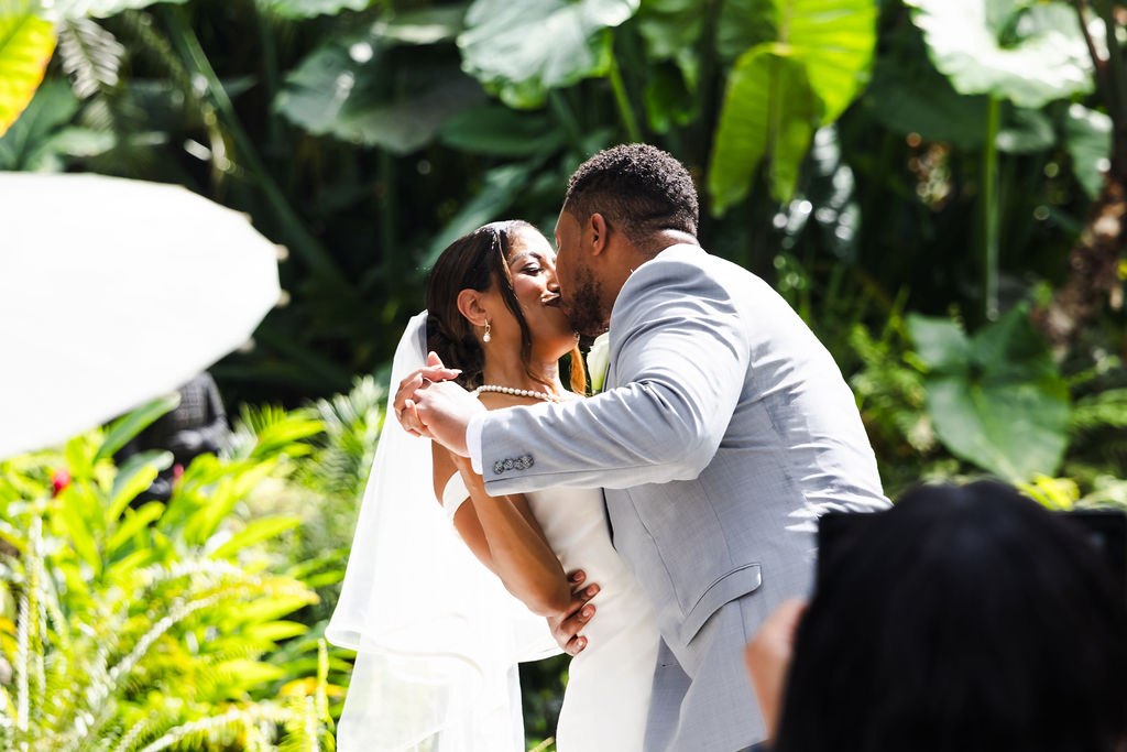 Adrian and Sharlena sharing their first kiss at the garden ceremony
