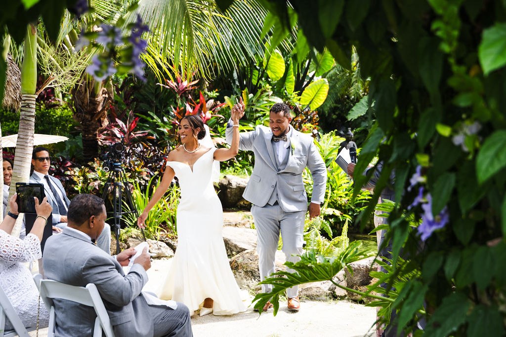 The newlyweds raising their hands as guests celebrate