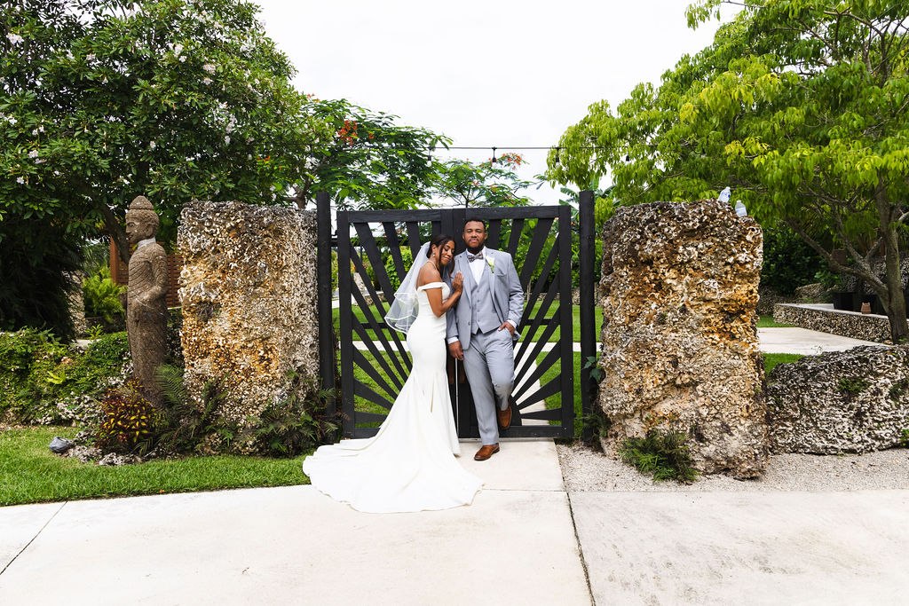 Adrian and Sharlena at ElopeWe’s gate between textured stone walls