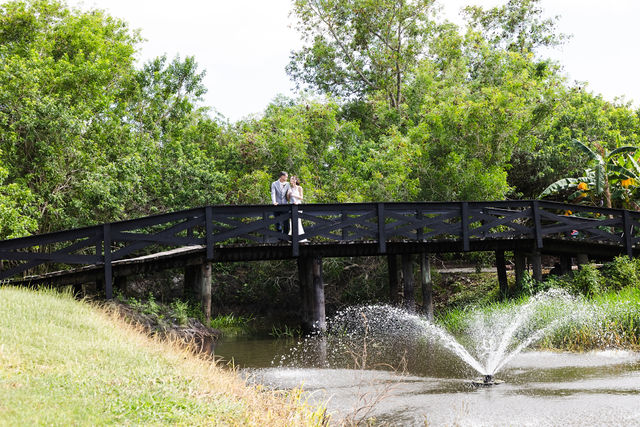 Wide view of the newlyweds on the black ranch bridge