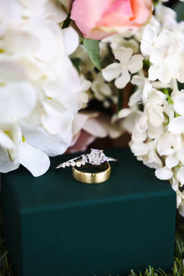 Wedding rings nestled among white flowers