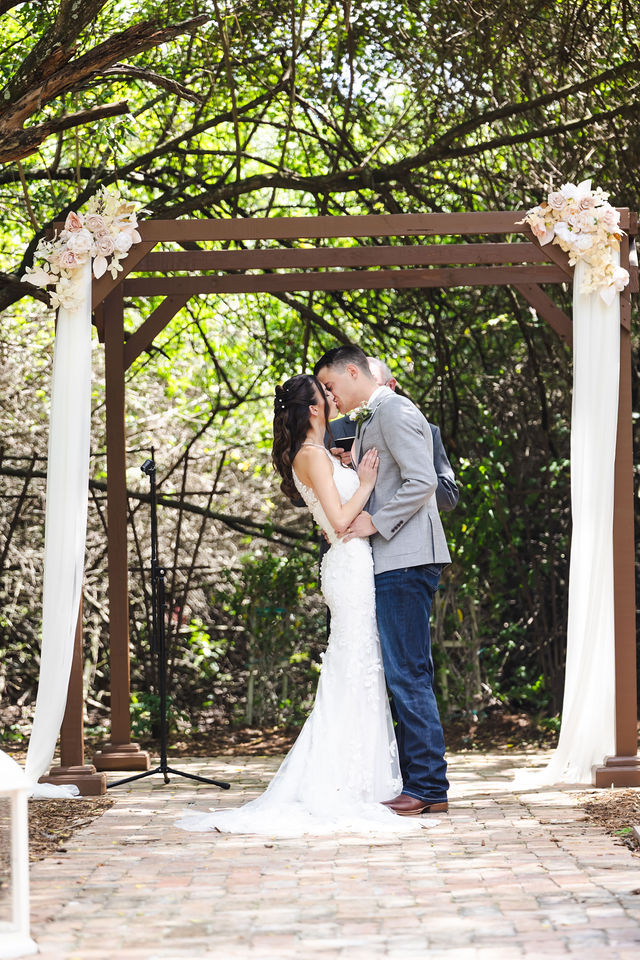 Haley and Trace kissing beneath the ceremony arbor