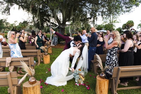 Ayrton dipping Nina in the aisle as their wedding guests celebrate