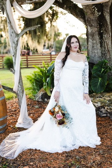 Nina holding her bouquet beneath the oak tree and ceremony draping