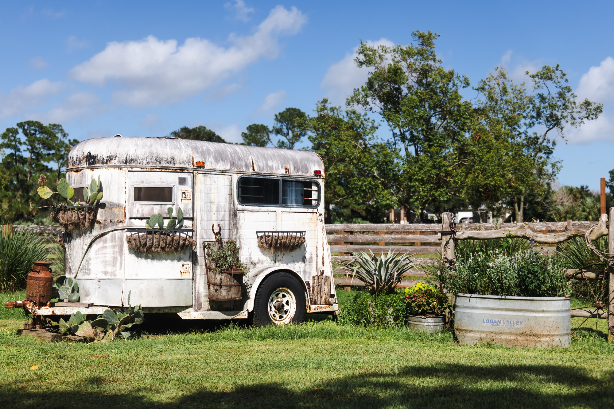 Vintage horse trailer, cactus planters and wooden fencing at Rockin H Ranch