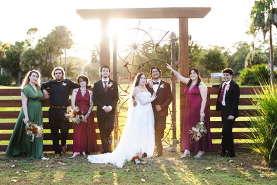 Nina, Ayrton and their wedding party beside the ranch gate at sunset