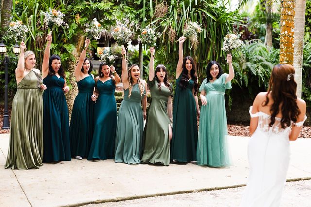 Sarah celebrating with bridesmaids in layered green dresses