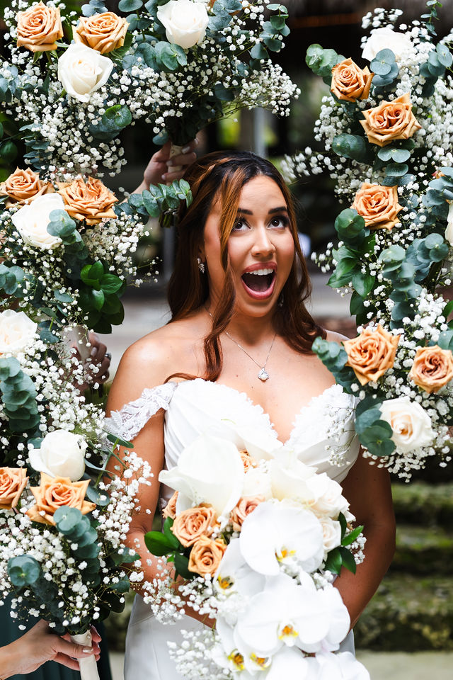 Joyful bridal portrait framed by lush florals
