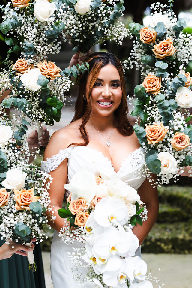 Sarah holding a bouquet of ivory and peach flowers