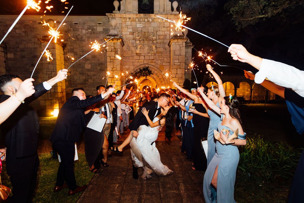 Dao and Karina celebrating beneath sparklers outside the illuminated monastery